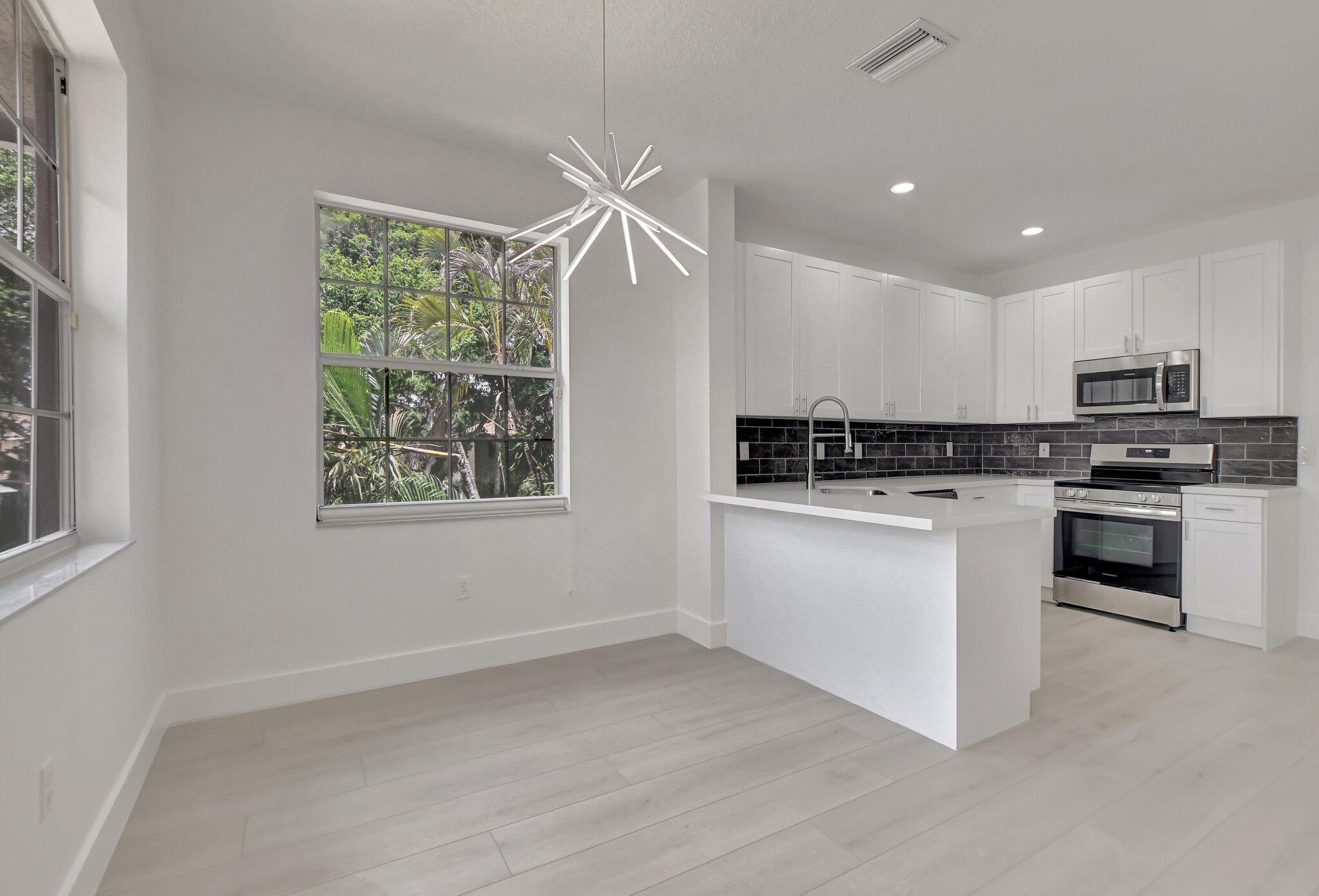 a kitchen with granite countertop white cabinets and white appliances