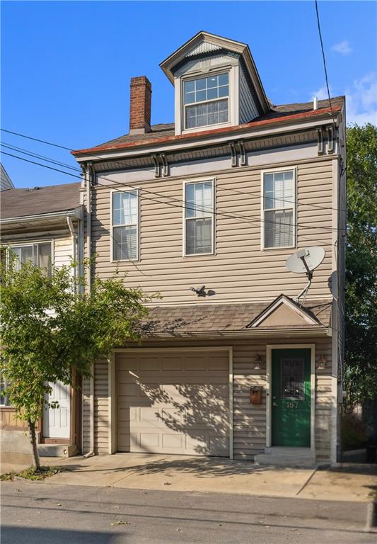 a front view of a house with a tree