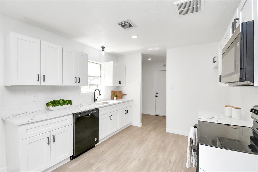 a kitchen with stainless steel appliances a sink stove and cabinets