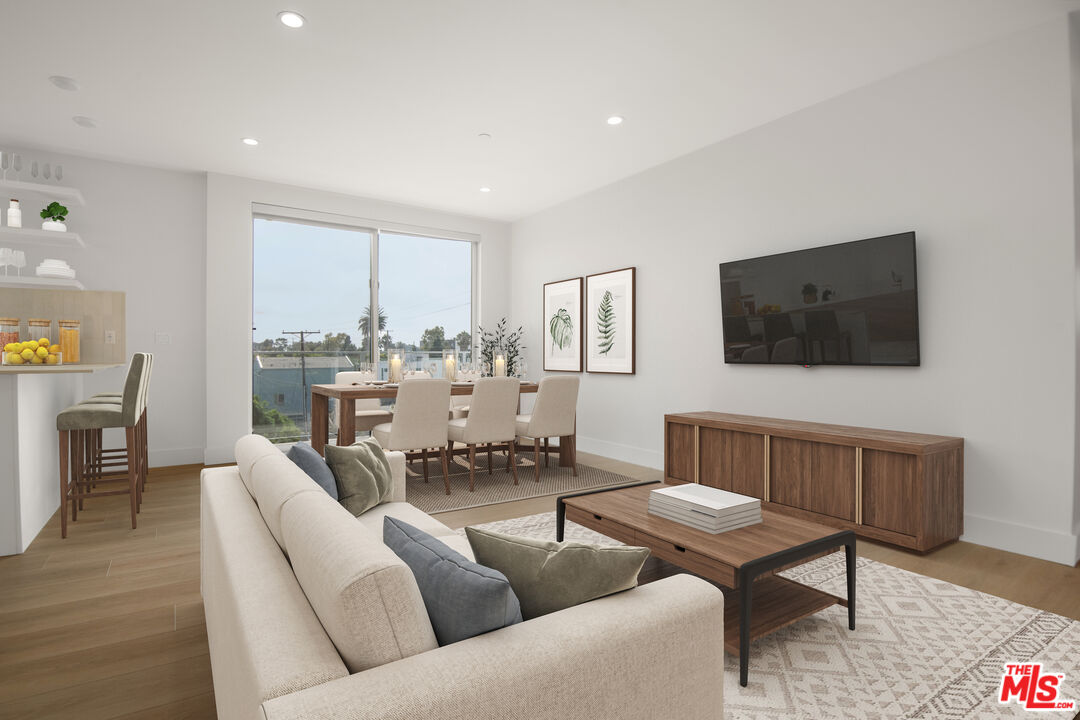 a living room with furniture a flat screen tv and a window