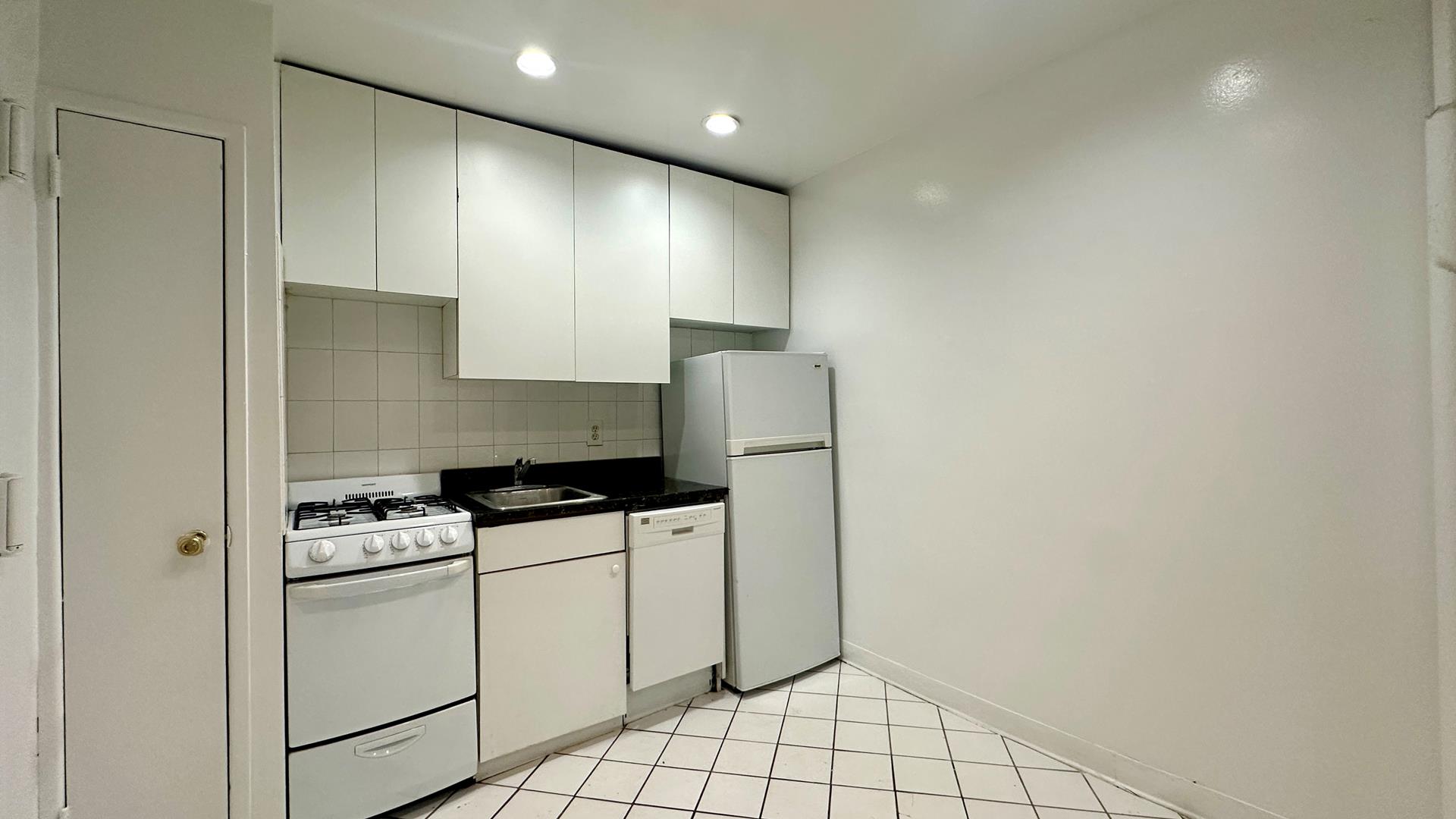 a kitchen with a stove cabinets and a refrigerator