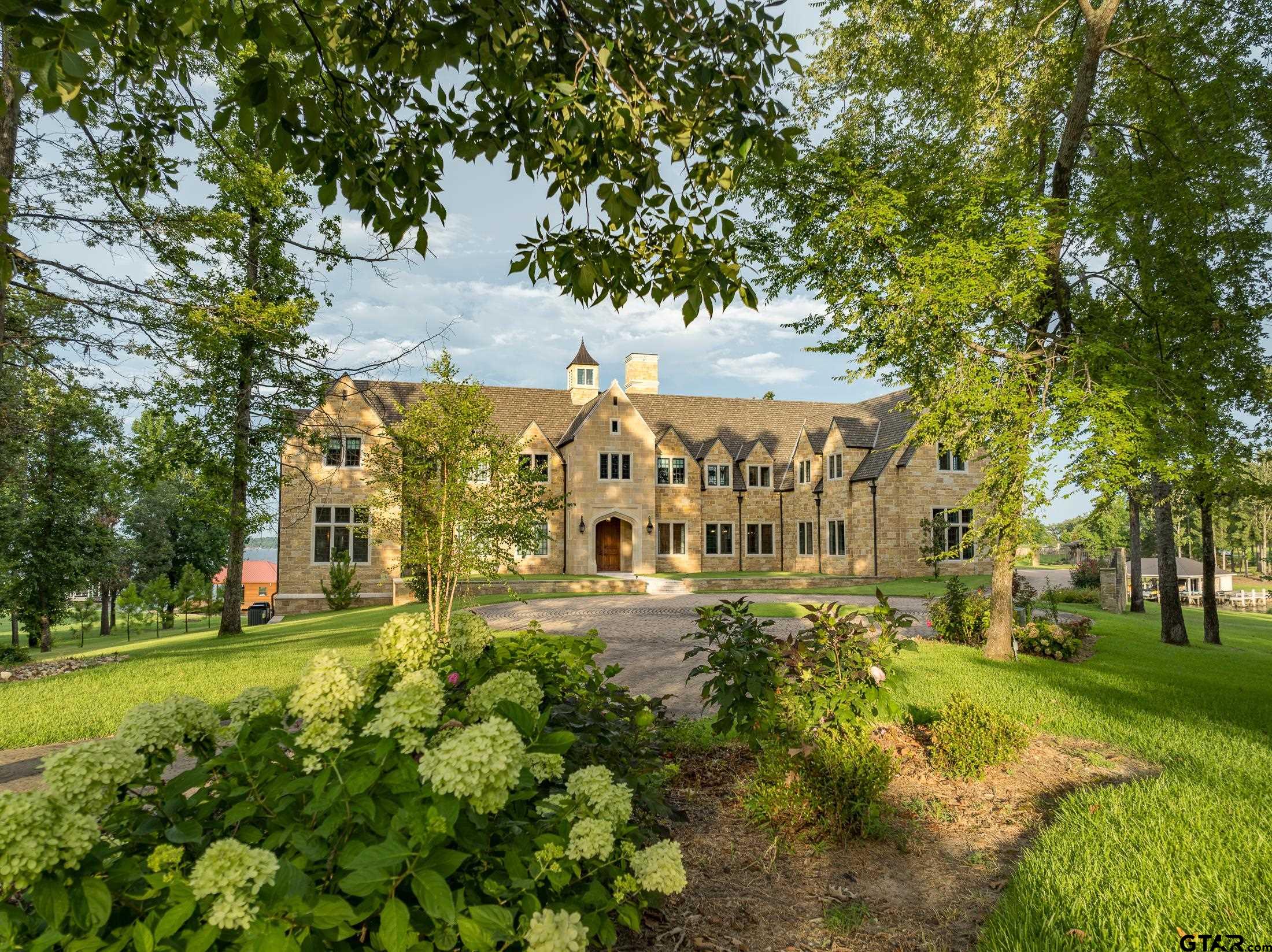 a view of a big building with big yard and large trees