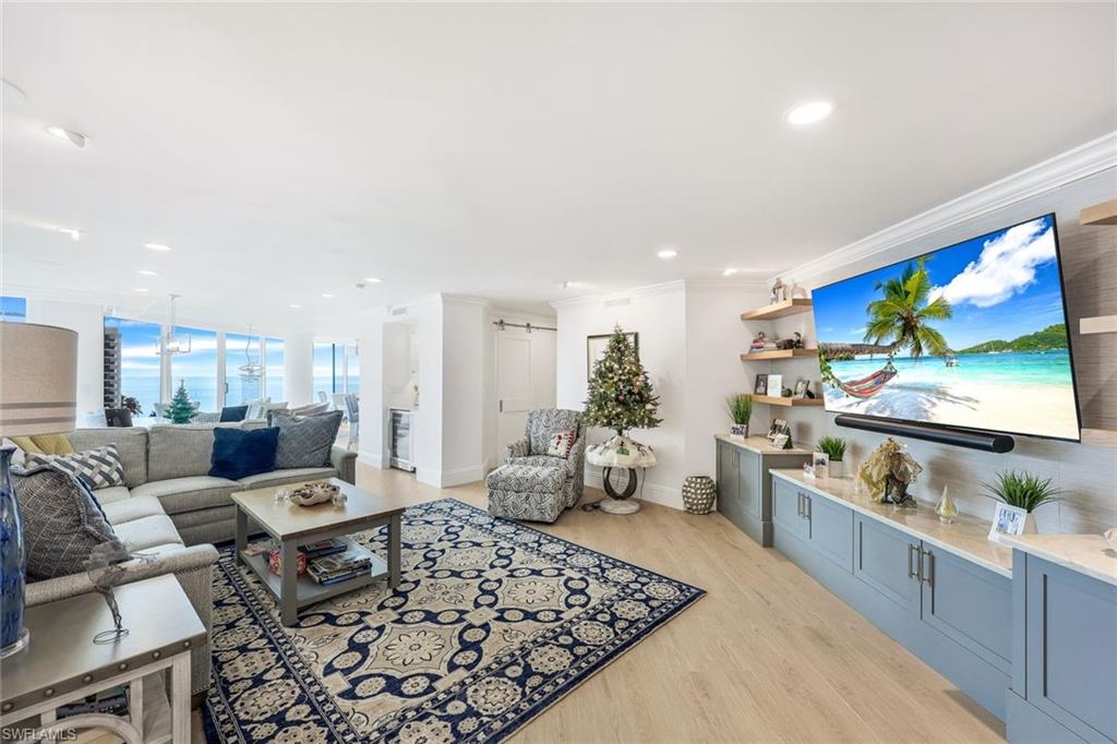 Living room with light hardwood / wood-style floors and crown molding