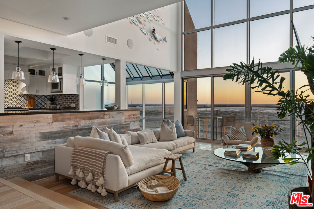 a living room with furniture and a floor to ceiling window