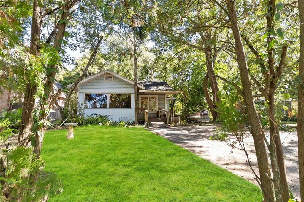 a front view of a house with a garden and trees