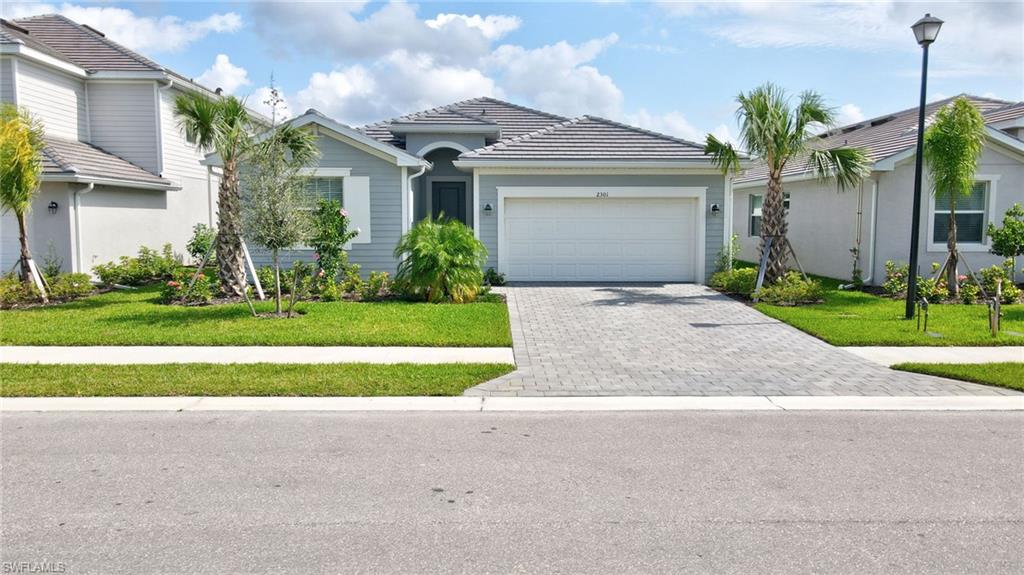 a front view of a house with a yard and garage