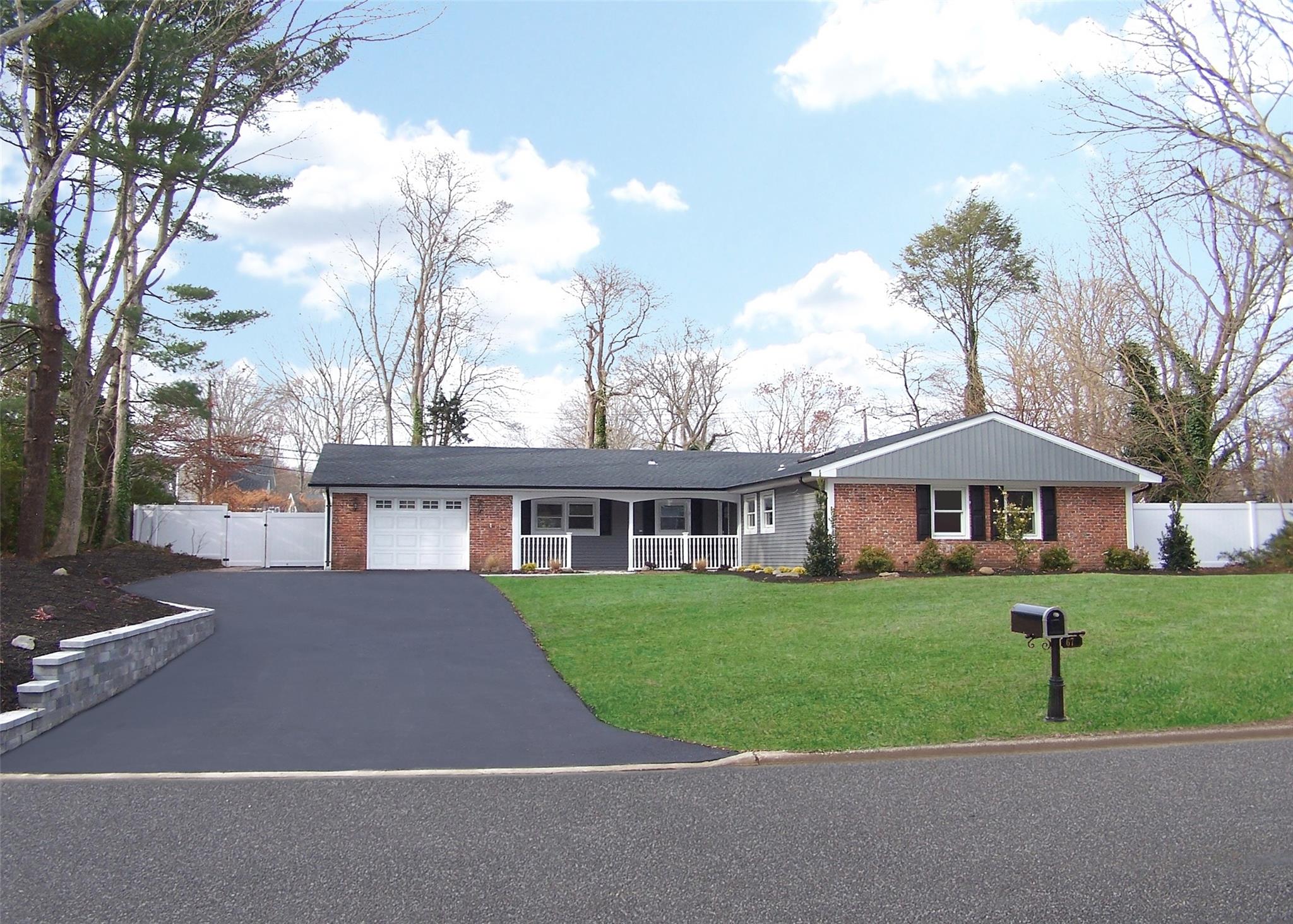 a front view of a house with a yard and trees