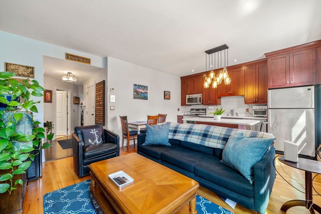 a living room with furniture and a dining table with kitchen view