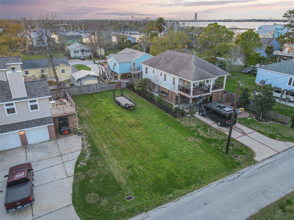 an aerial view of residential houses with outdoor space and trees