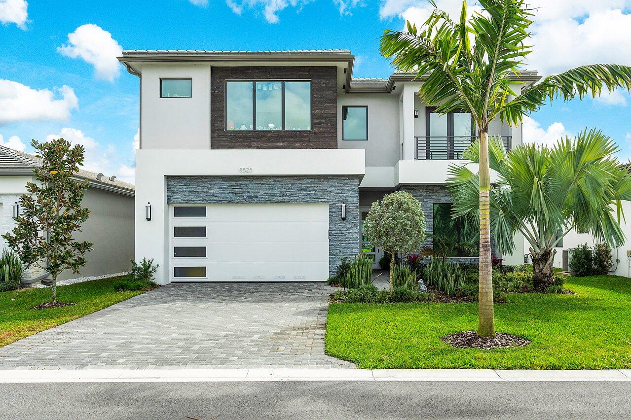 a view front of house with a yard and palm trees