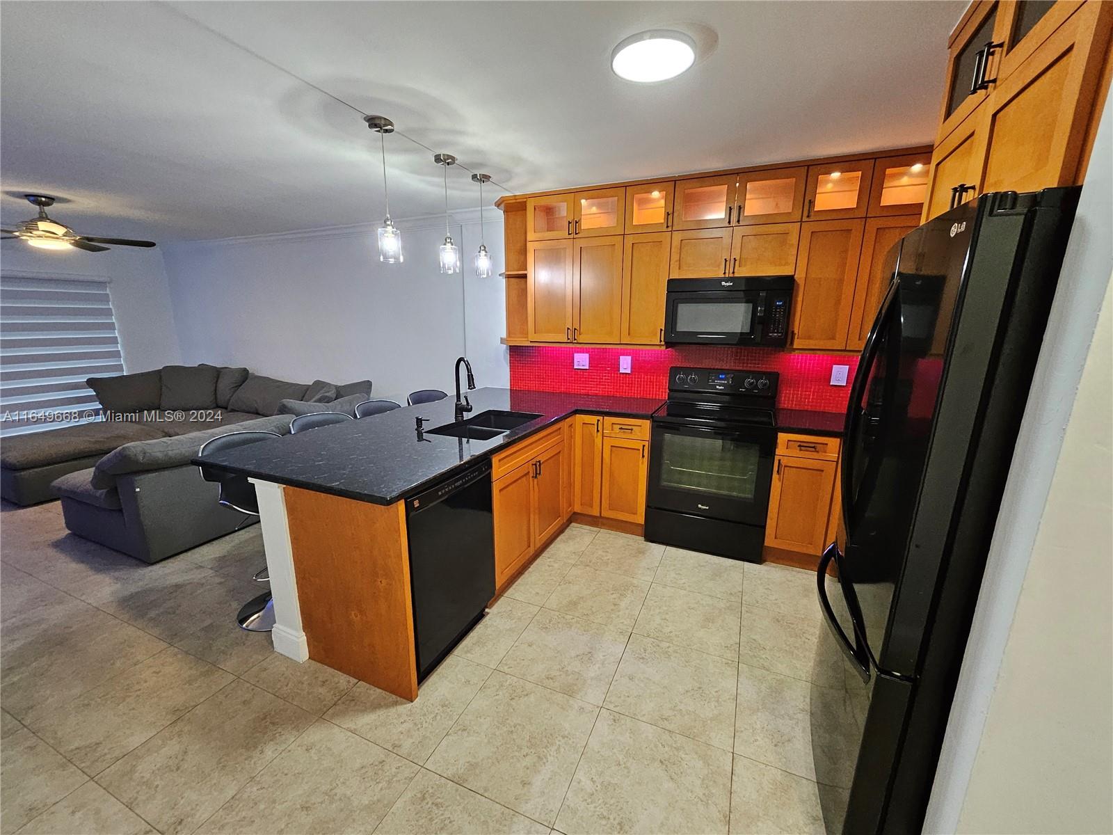 a kitchen with stainless steel appliances granite countertop a sink and a refrigerator