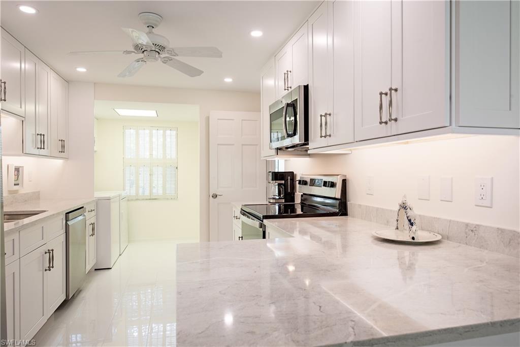 a kitchen with stainless steel appliances granite countertop a sink and cabinets