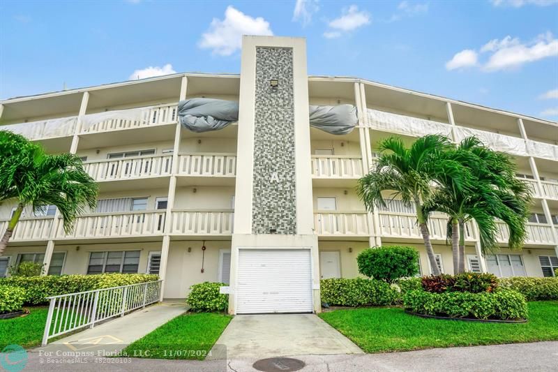 a front view of a building with a garden and plants