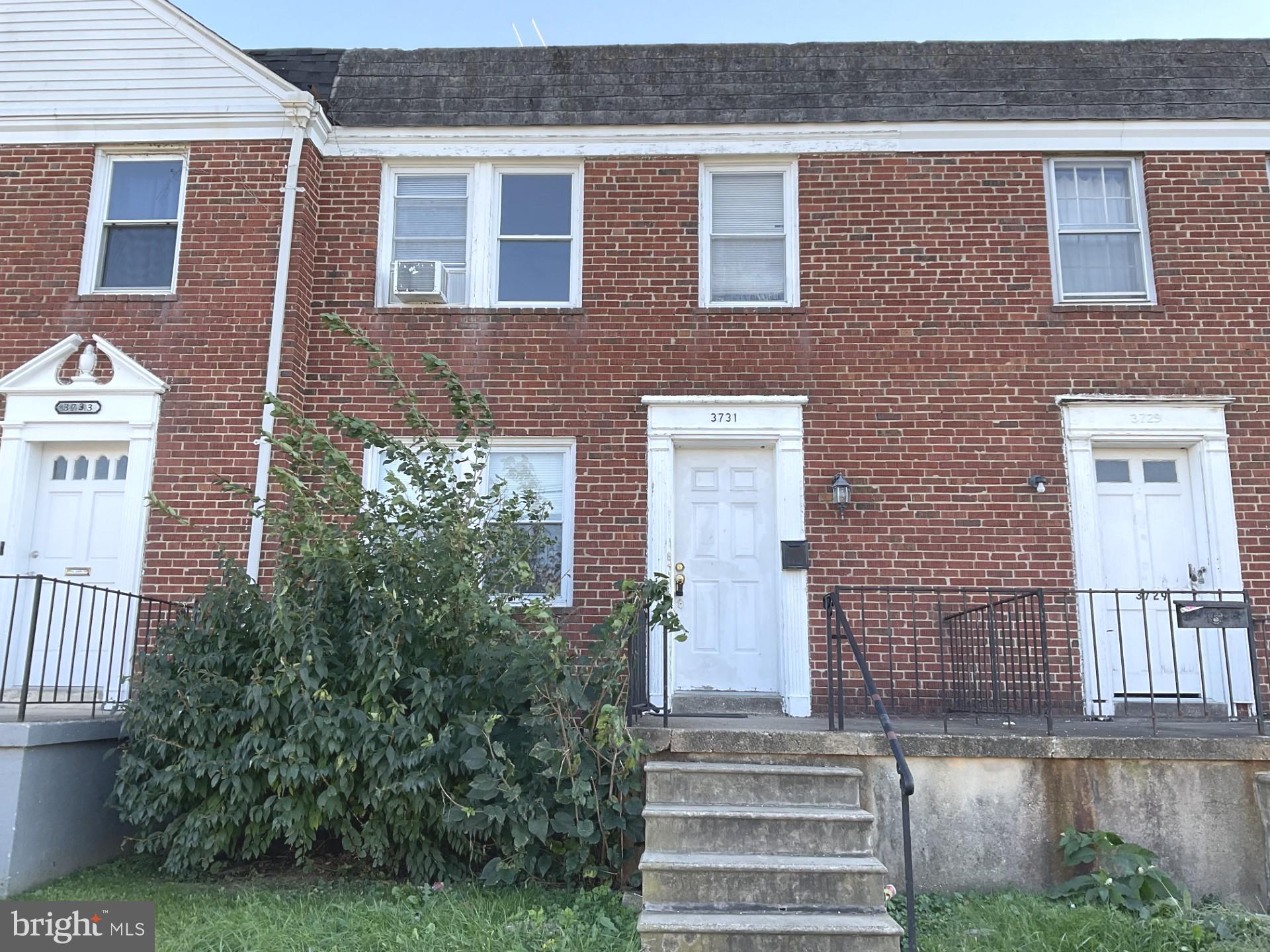 a front view of a house with plants and garden