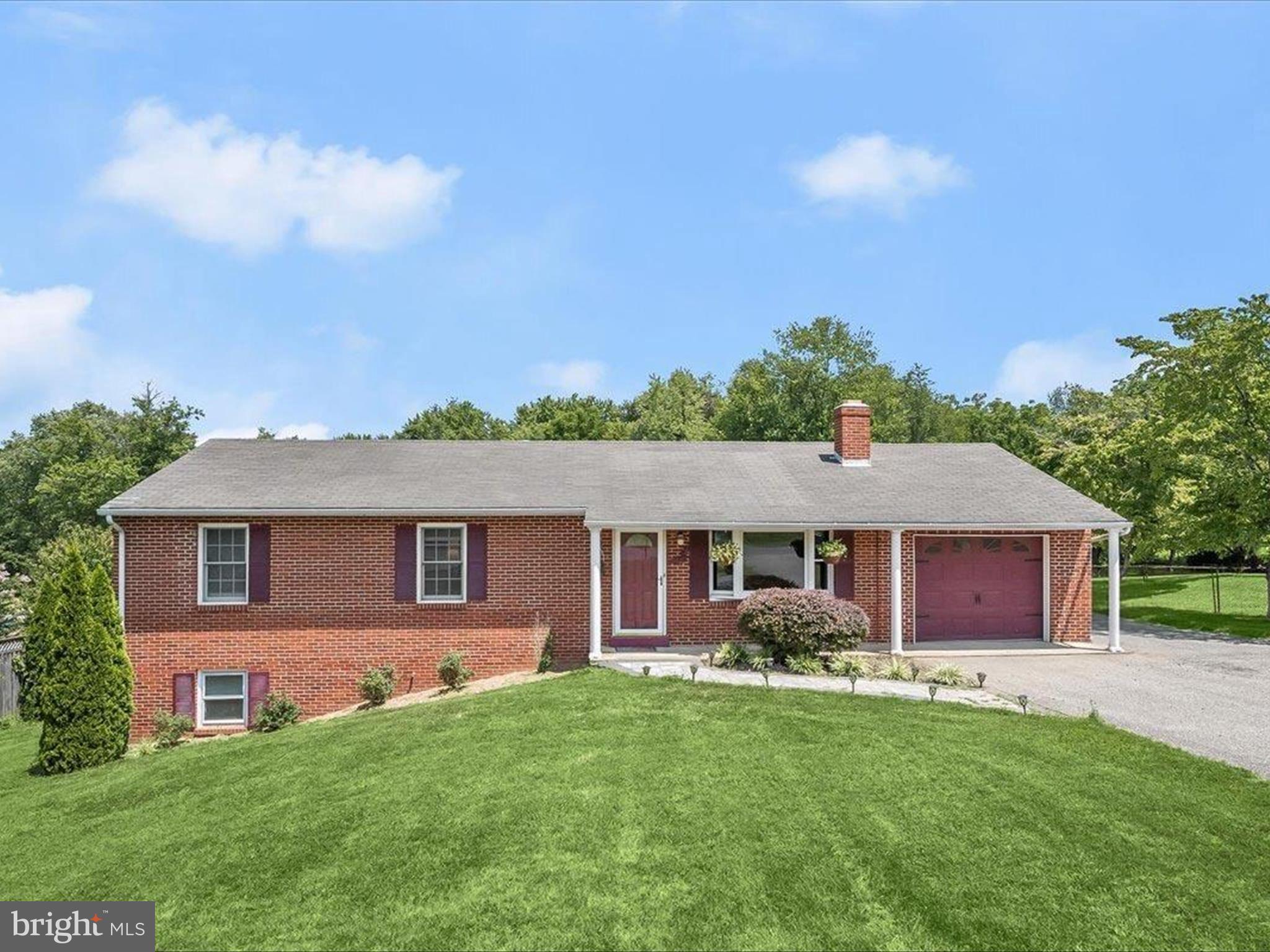 a front view of a house with yard and green space