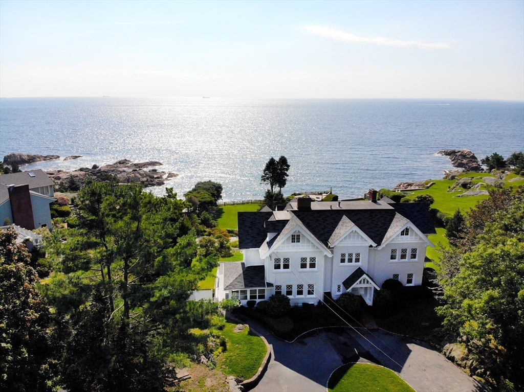 an aerial view of a house with a swimming pool and ocean view