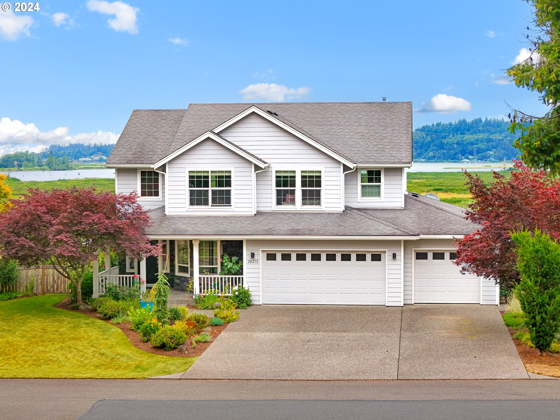 a view of a house with a yard and potted plants