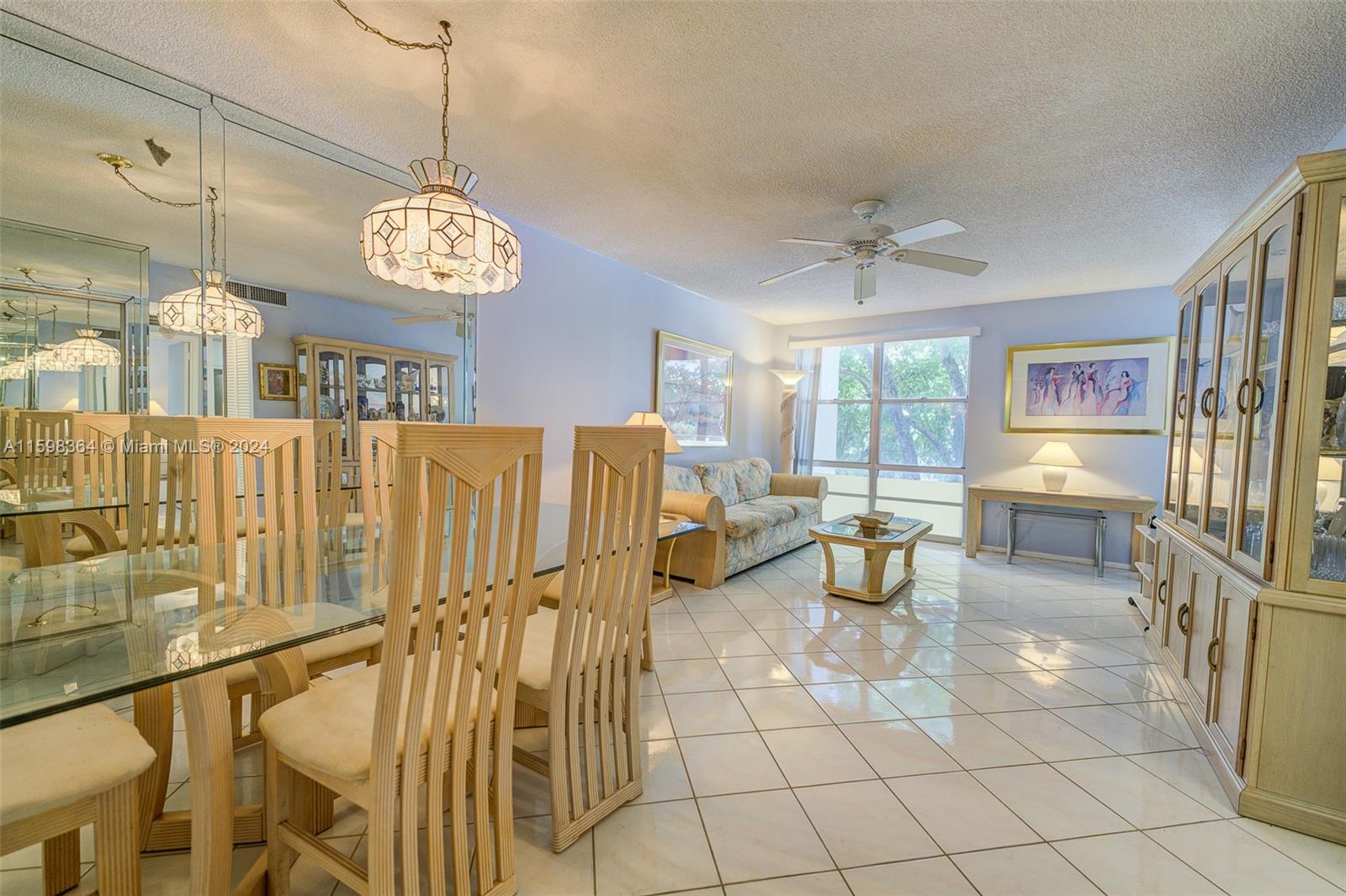 a view of a dining room and livingroom with furniture wooden floor a chandelier