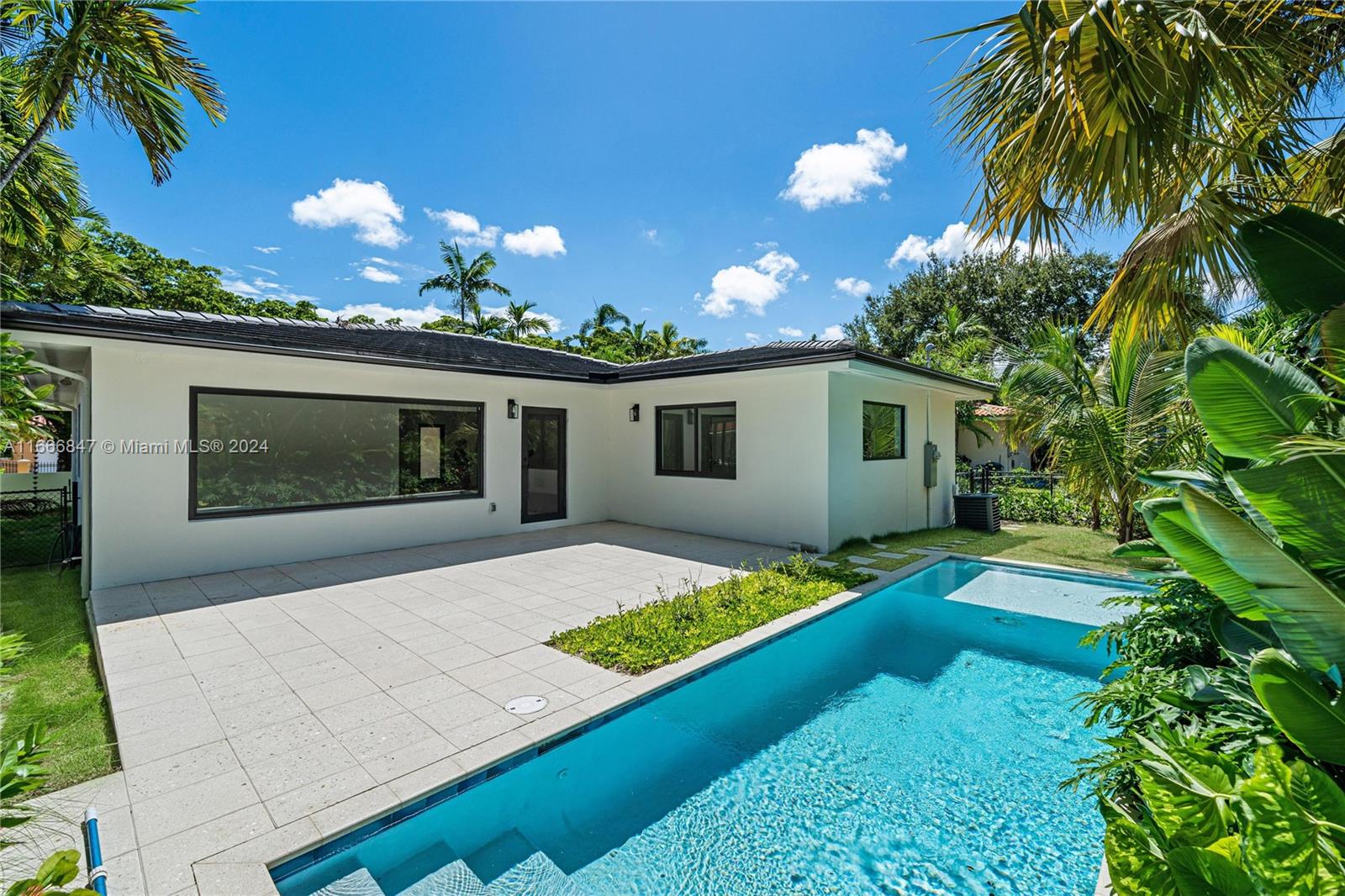 a view of a house with backyard and sitting area