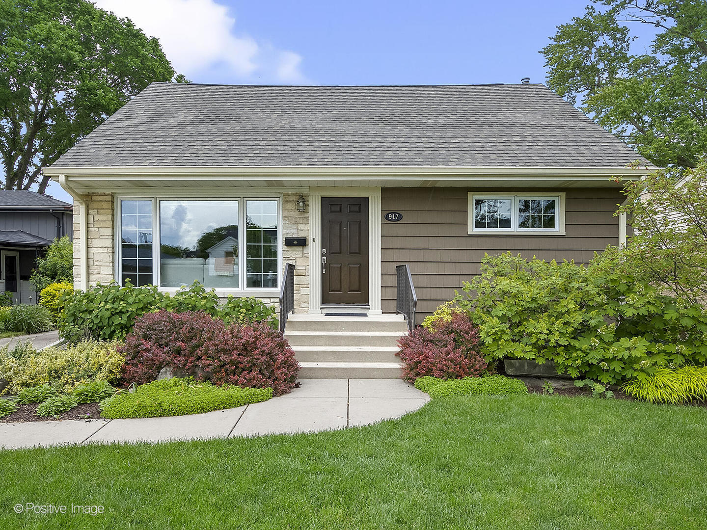 a front view of a house with a yard and plants