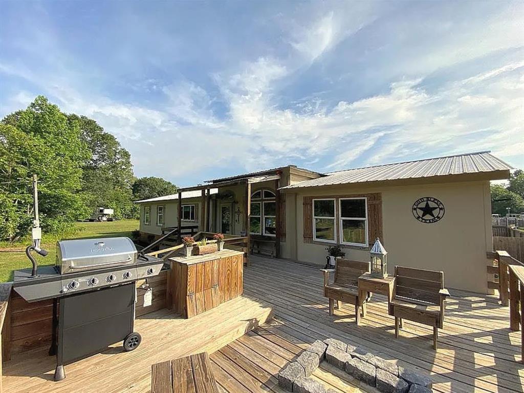 a view of a patio with table and chairs with wooden floor and fence