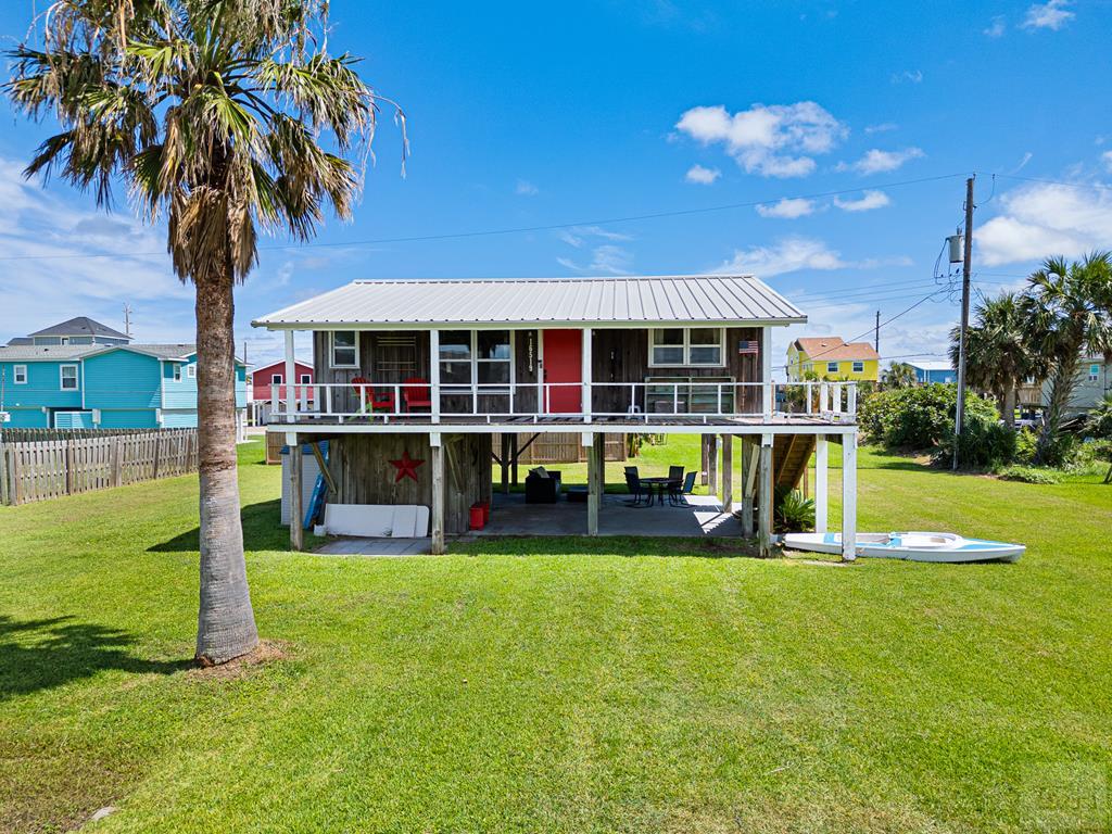 a view of a house with a yard and palm trees