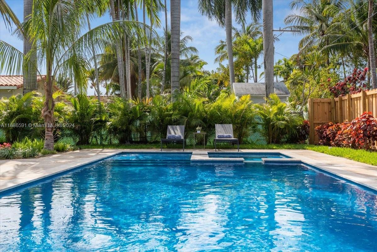 a view of a swimming pool with a bench and trees