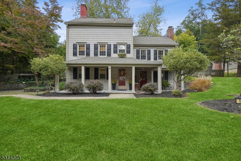 a front view of a house with swimming pool and garden