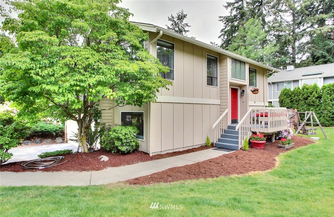 a front view of a house with a yard and trees