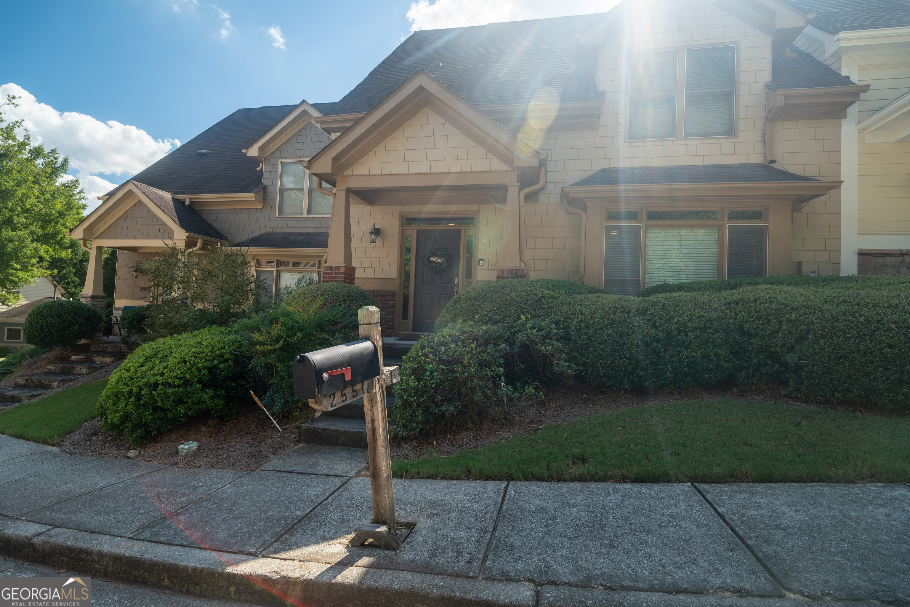 a front view of a house with a yard and trees