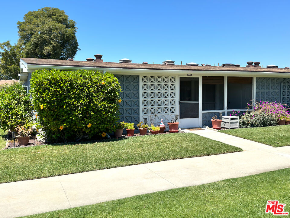 a front view of a house with a garden and plants