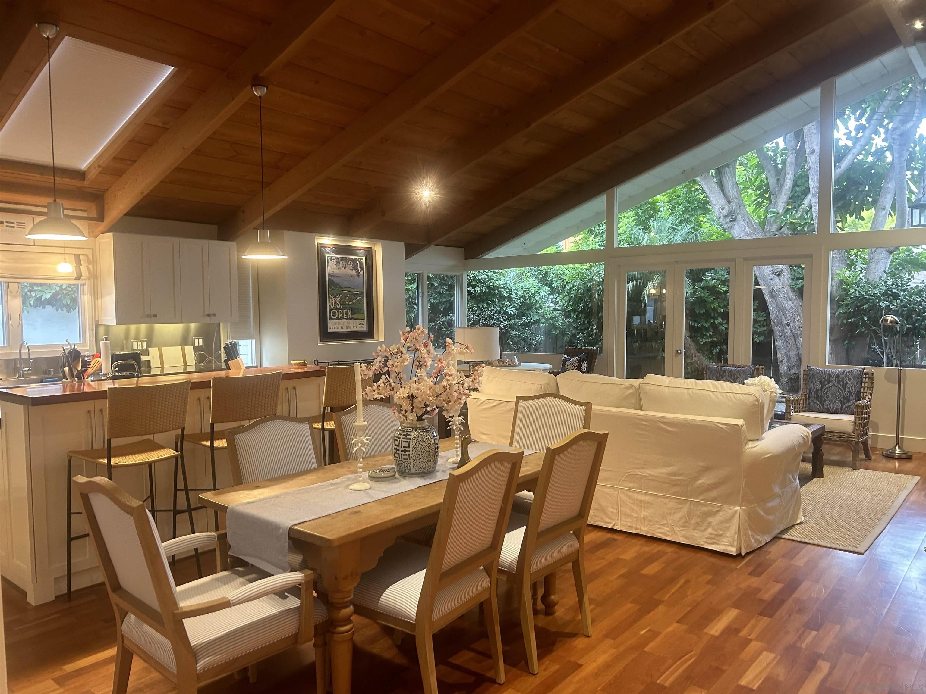 a view of a dining room with furniture large windows and wooden floor