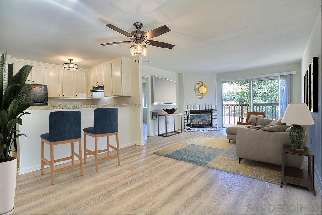 a living room with furniture a fireplace and a large window