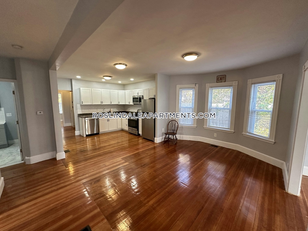 a view of a livingroom with furniture hardwood floor and a kitchen