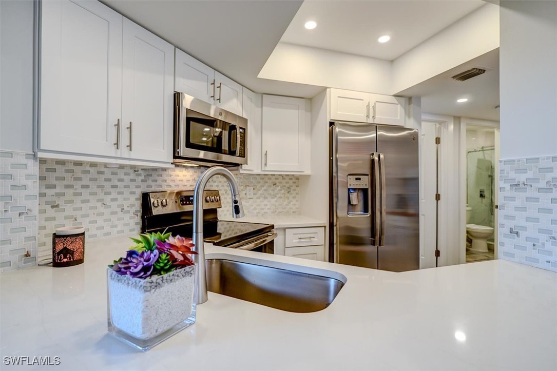 a kitchen with a refrigerator and a stove top oven