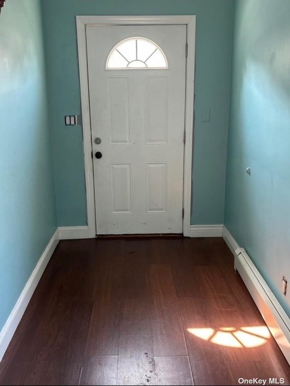 en empty room with wooden floor and a window