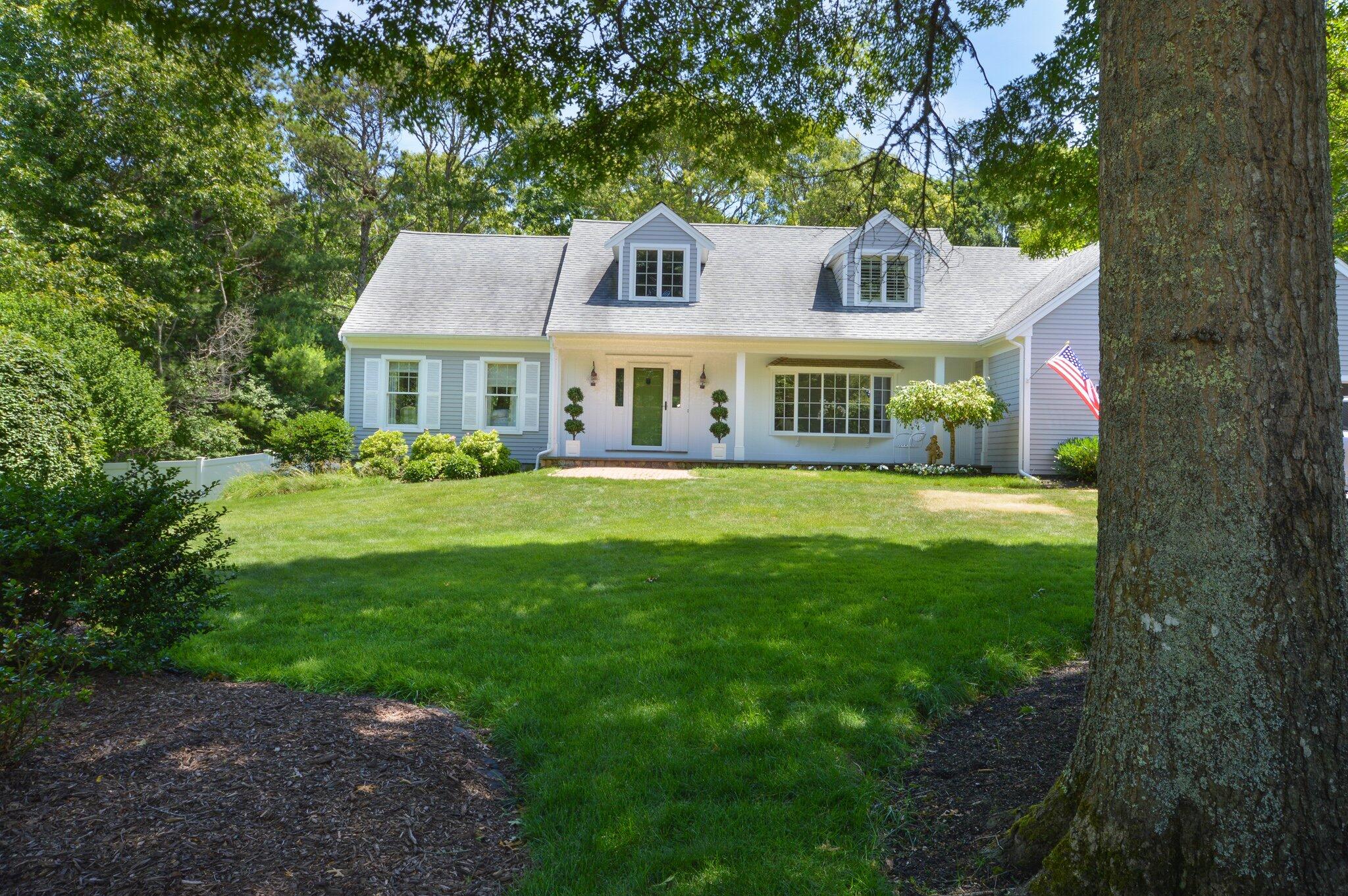 a front view of a house with yard and green space