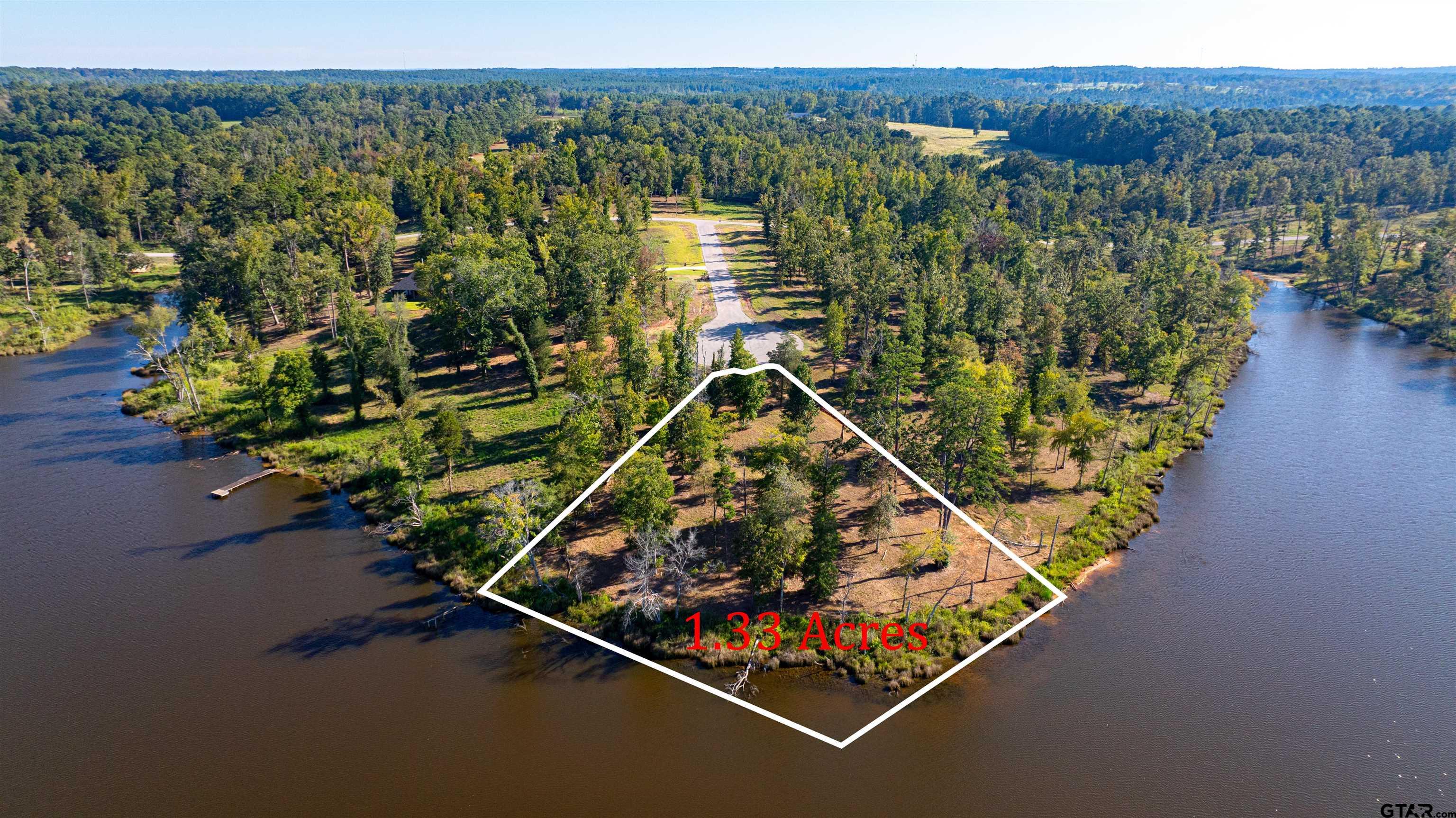 an aerial view of a residential houses with a yard and lake view