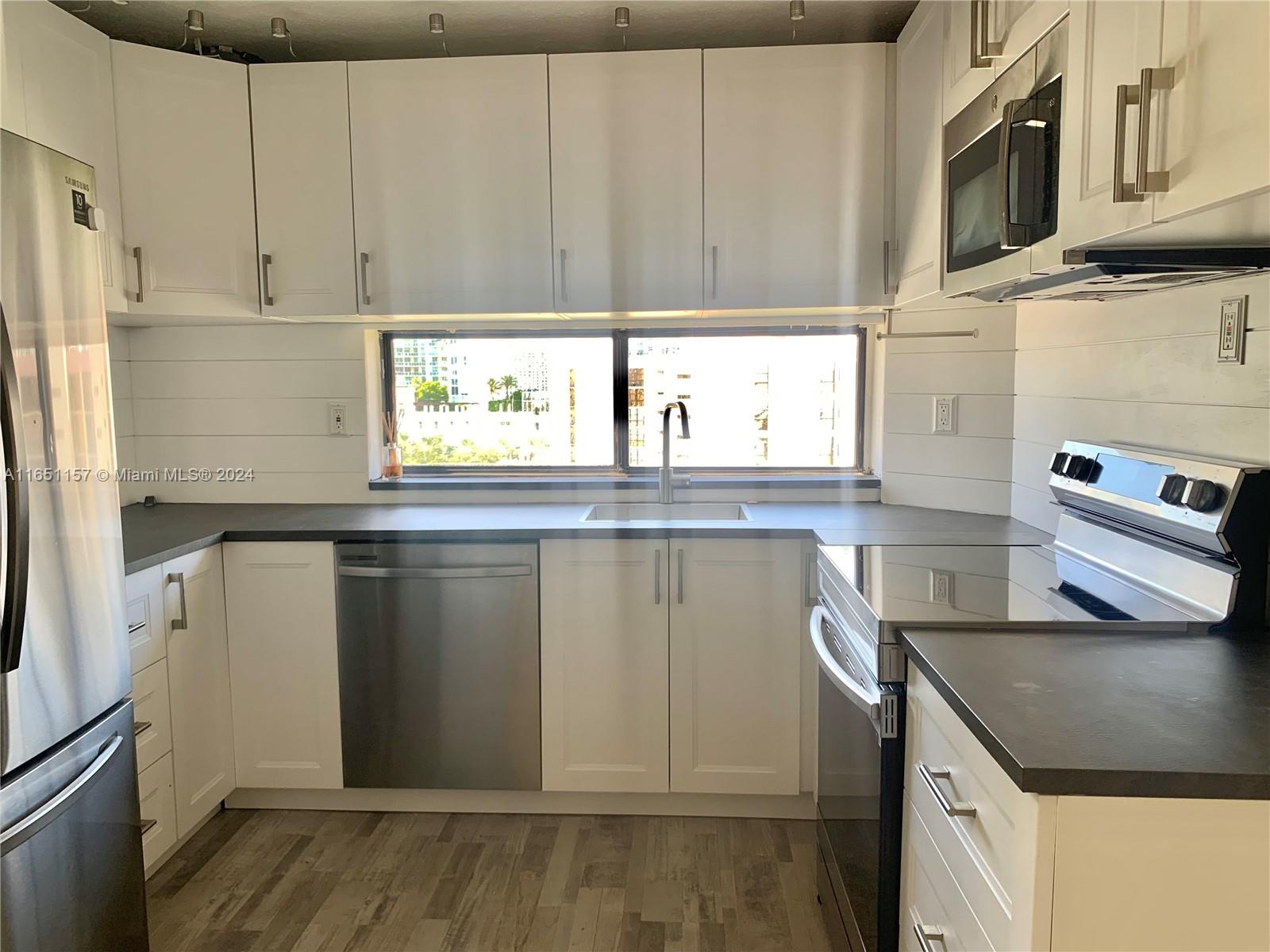 a kitchen with stainless steel appliances granite countertop a refrigerator and a stove