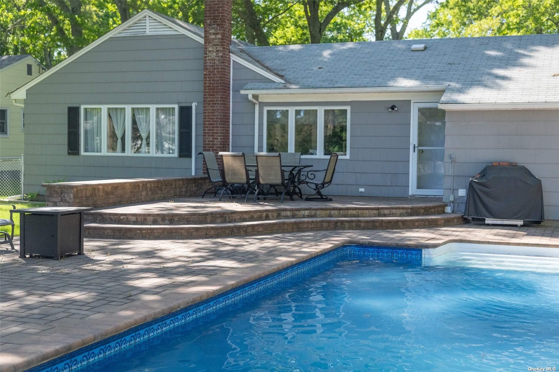 a view of a house with backyard and sitting area