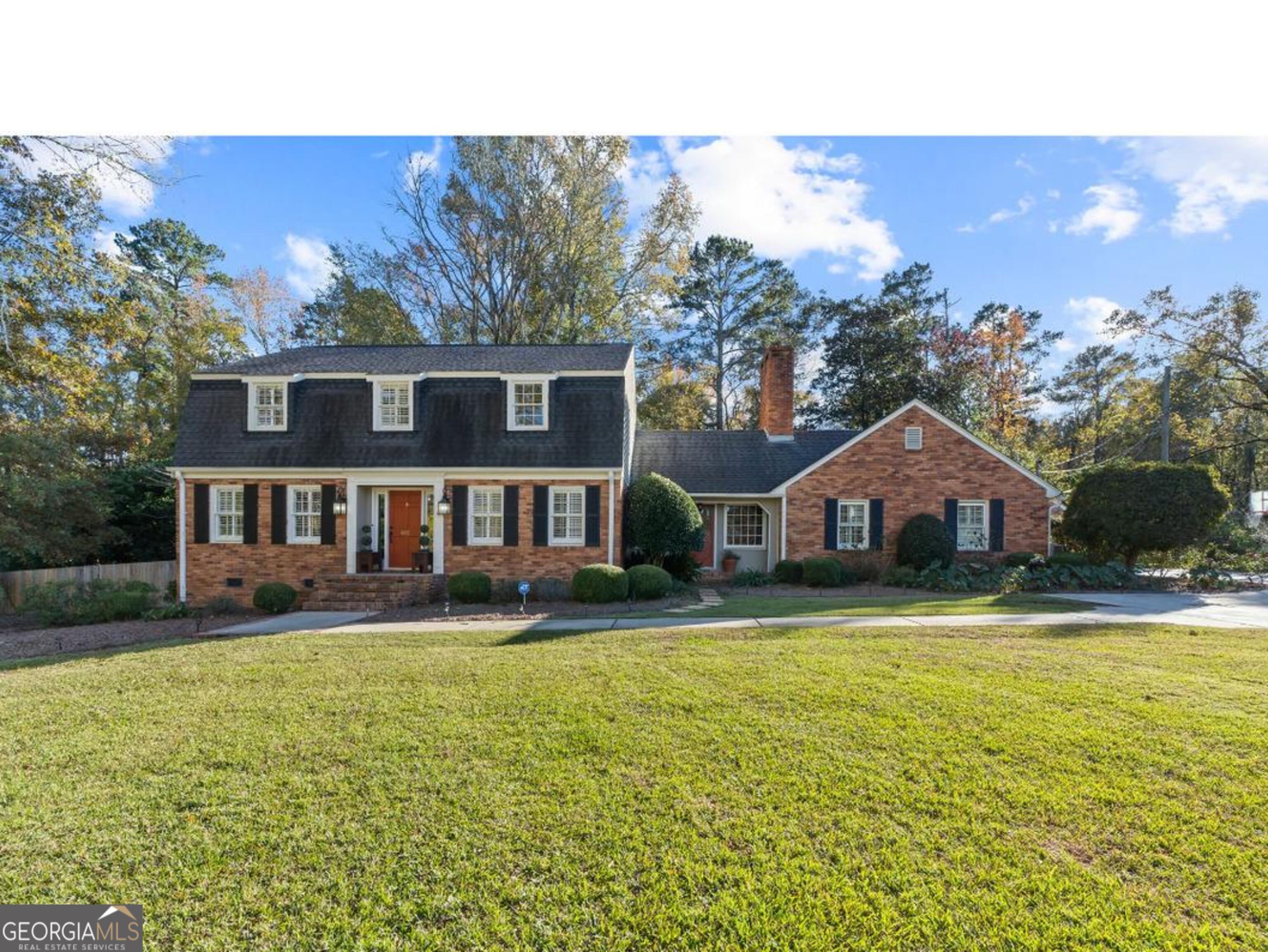 a front view of a house with yard and green space