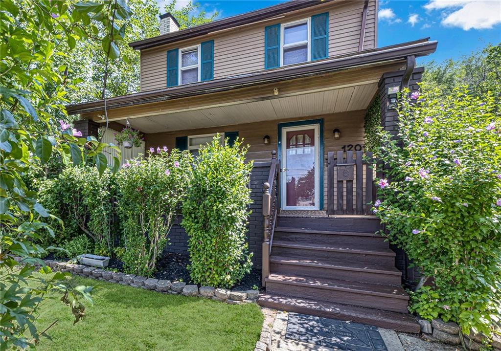 a view of a house with potted plants and a table and chairs