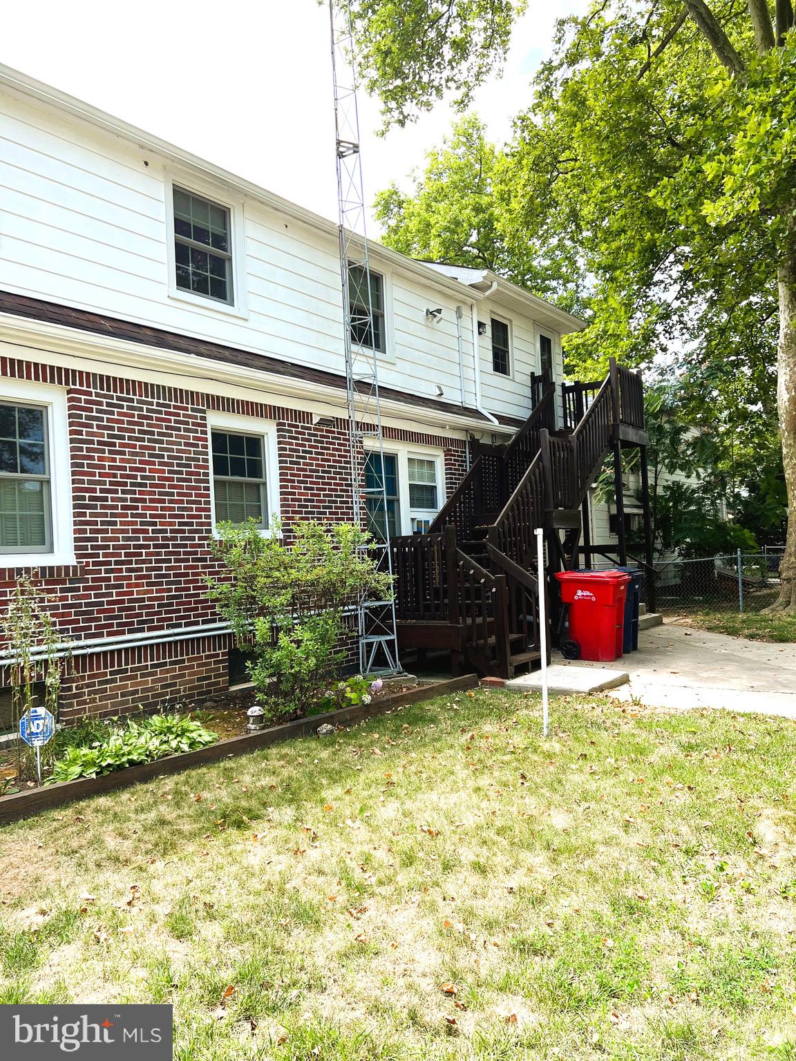 a backyard of a house with plants and wooden fence