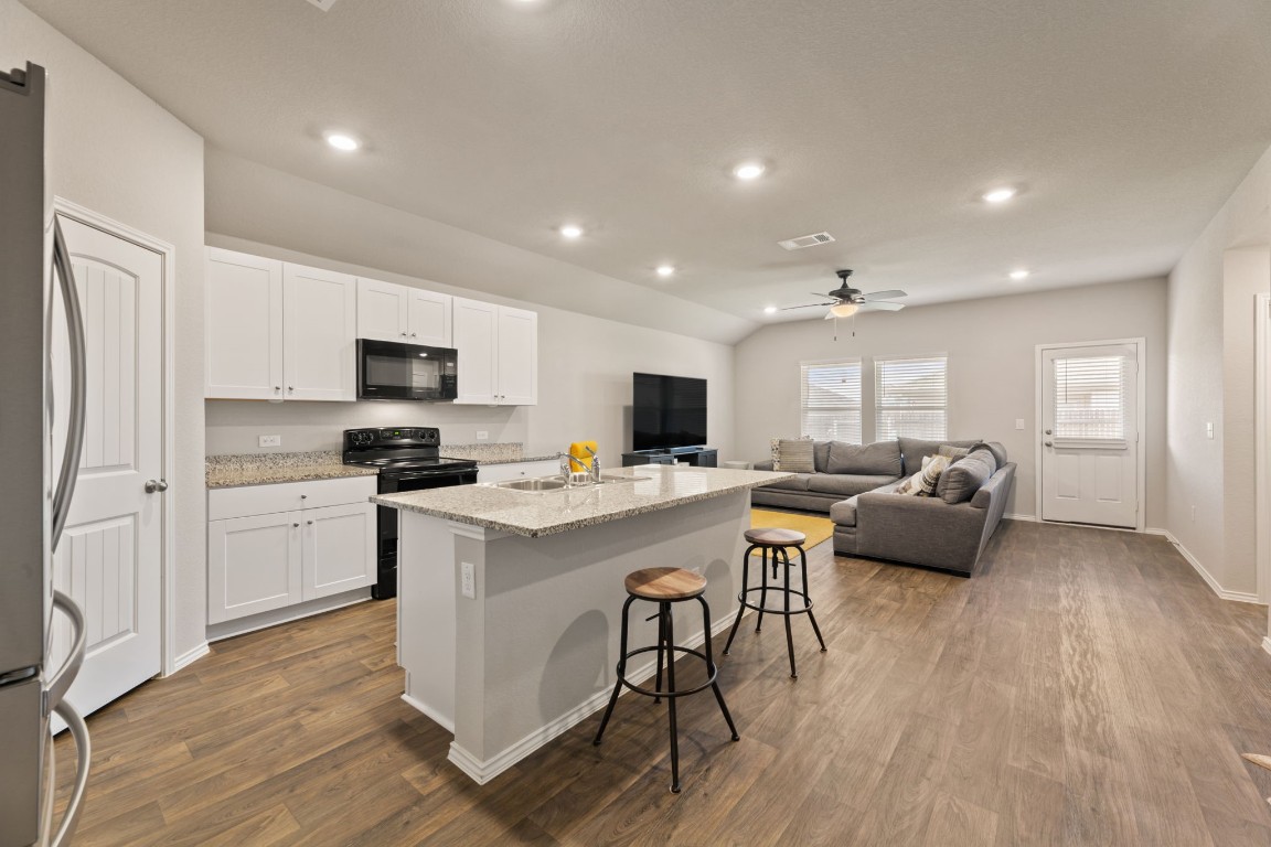 a kitchen with a sink a counter top space stainless steel appliances and cabinets