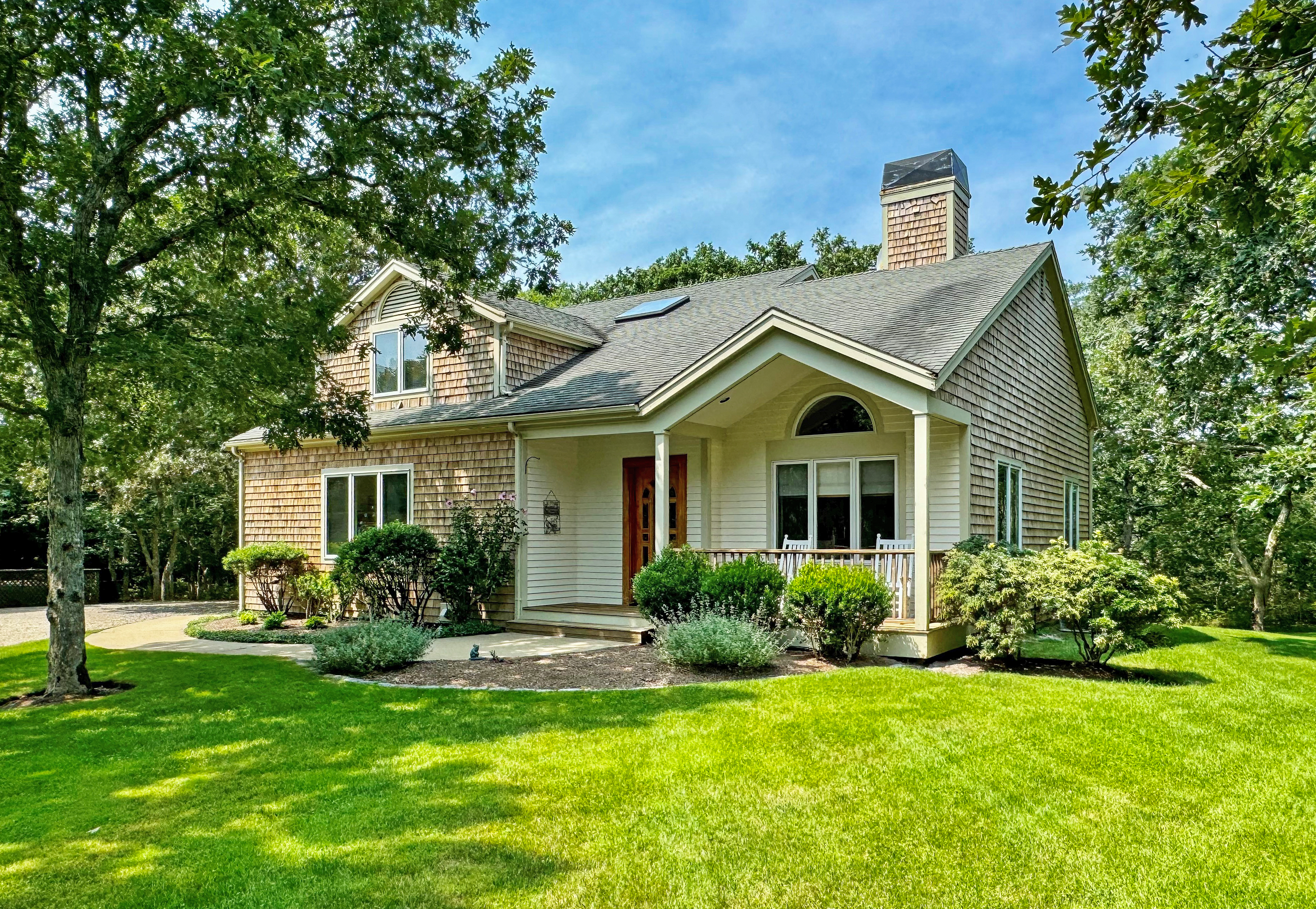 a view of a house with a big yard plants and large trees