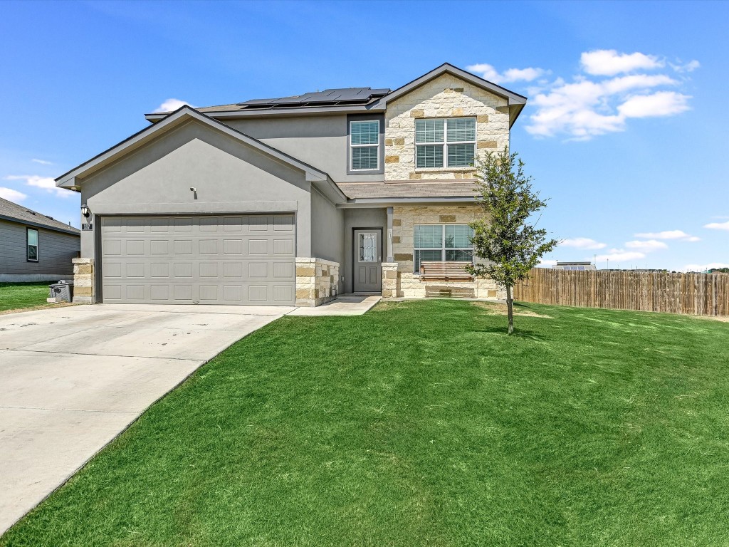 a front view of a house with a yard and garage