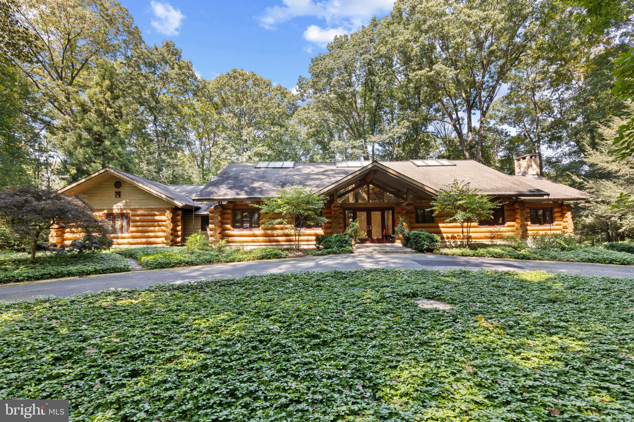 a view of a big house with a big yard and large trees