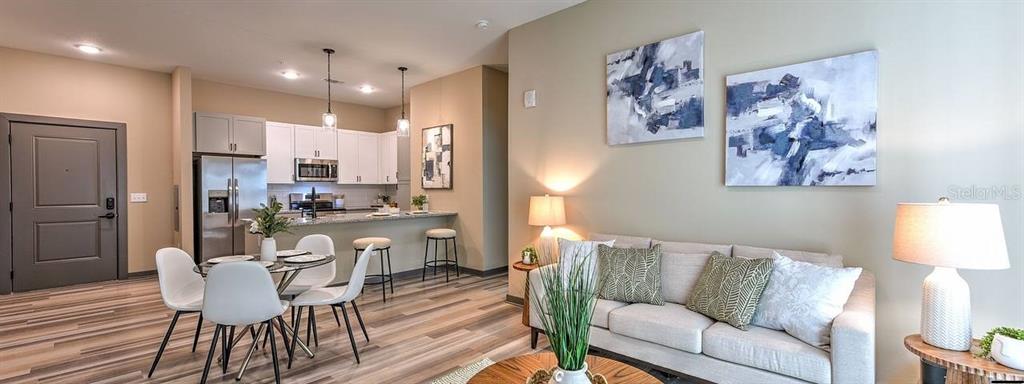 a living room with stainless steel appliances kitchen island granite countertop furniture and a couch