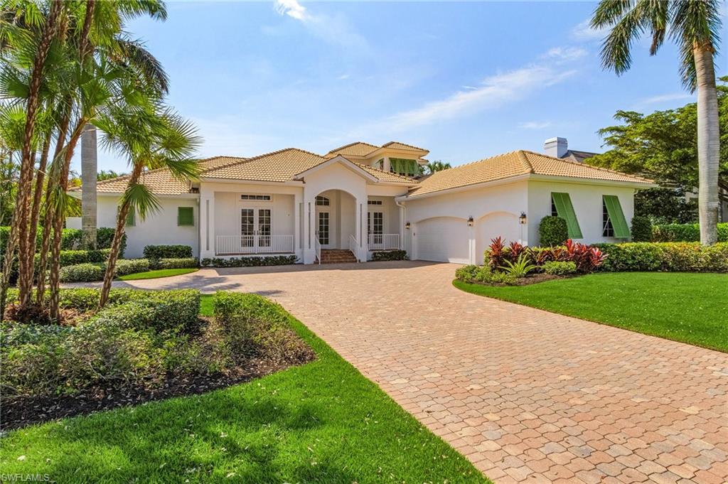 a front view of a house with a garden and trees