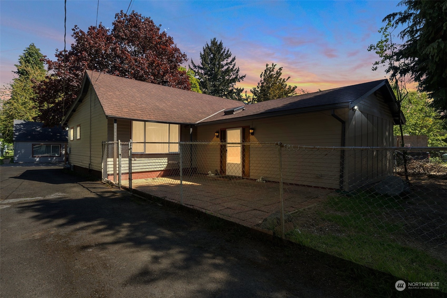 a view of backyard of house with wooden fence